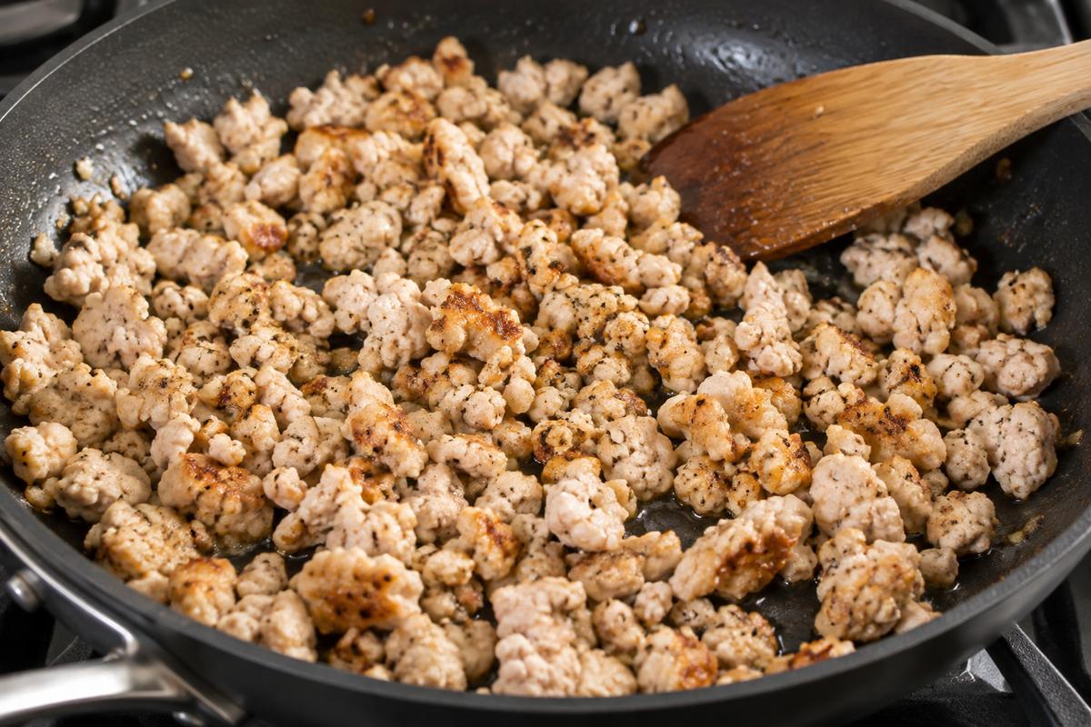 Delicious Ground Chicken Pasta Recipes You’ll Love 2 Ground chicken browning in a skillet, showing small pieces lightly browned.